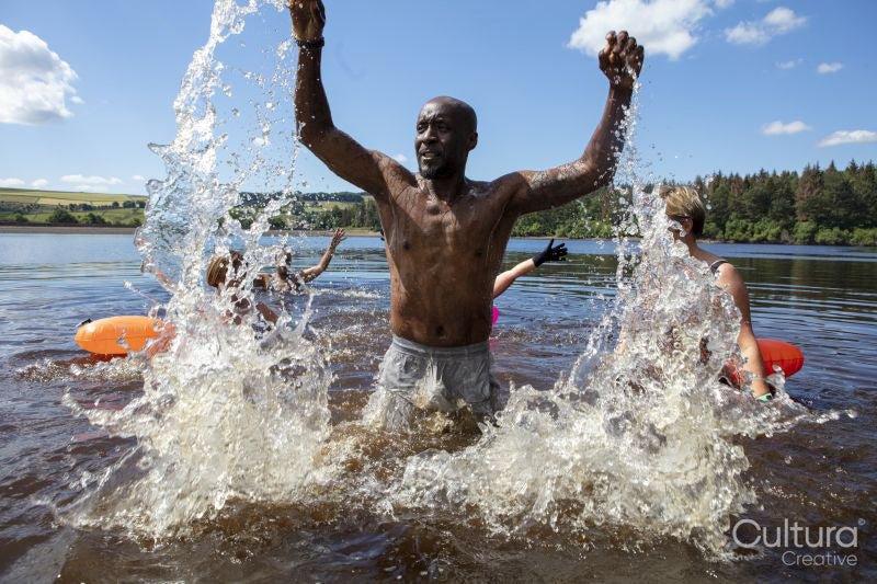 Man splashing water in lake, Yorkshire, UK