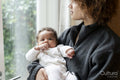 Mother holding baby daughter and looking out window