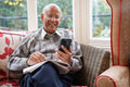 Smiling senior man using smart phone