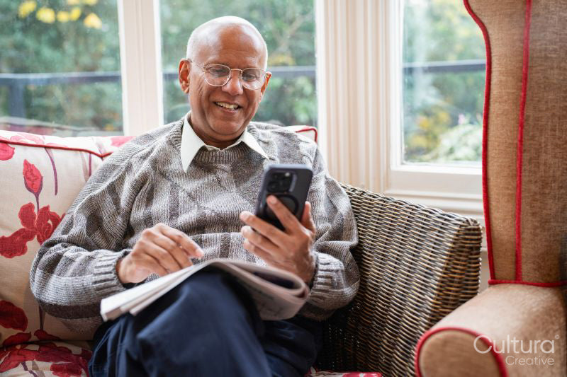 Smiling senior man using smart phone