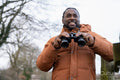 Man looking through binoculars in rural area