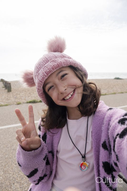Portrait of smiling girl making peace gesture while taking selfie
