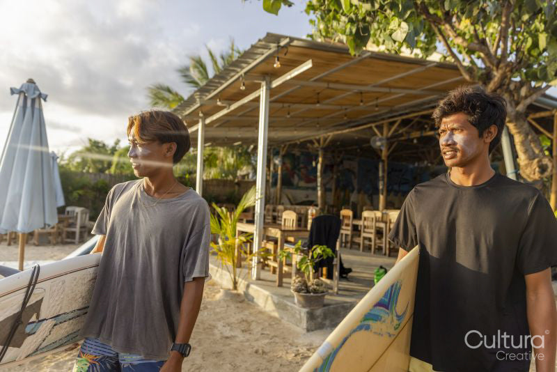 Surfers standing with surfboards on beach