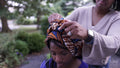 Mother putting traditional headdress on daughter