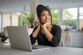 Teenage girl using laptop and thinking