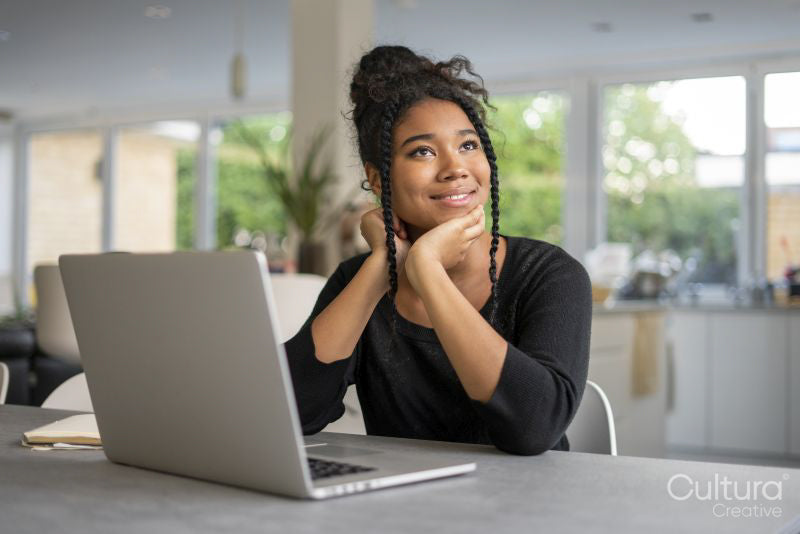Teenage girl using laptop and thinking