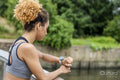 Sporty young woman checking time on wristwatch