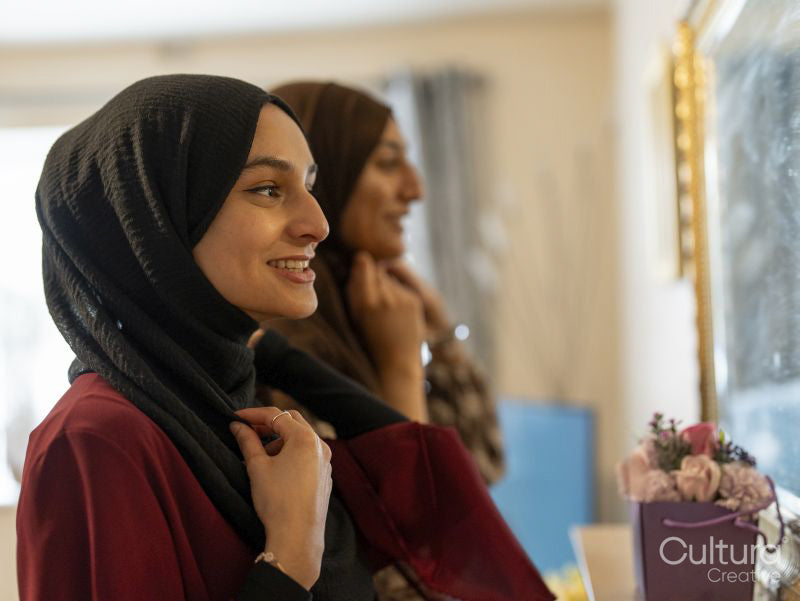 Women dressing hijabs for Ramadan celebration at home