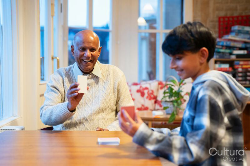 Senior man and grandson playing cards together