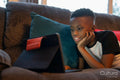 Boy with laptop lying on sofa