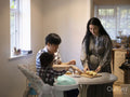 Parents with baby son preparing gift boxes with moon cakes
