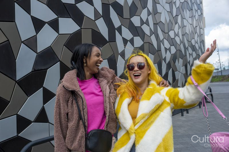 Stylish young friends laughing outdoors