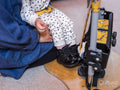 Mother putting daughter in standing frame