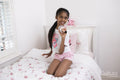 Smiling girl with microphone on bed