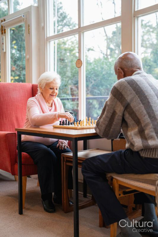 Senior people playing chess in nursing home