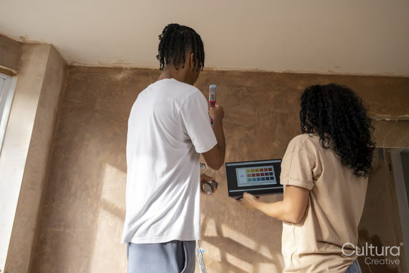 Mother and son looking at color samples on laptop in new house