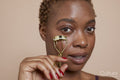 Studio portrait of woman using eyelash curler