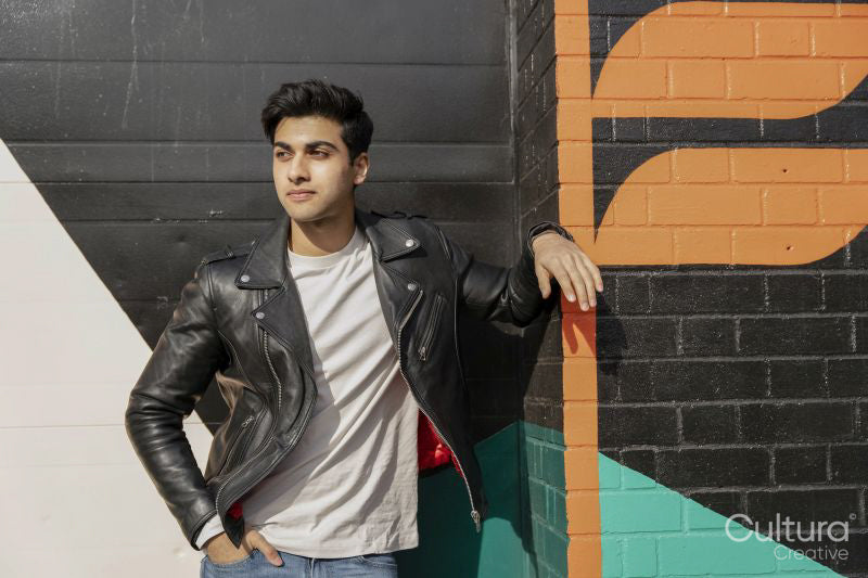 Young man leaning against wall