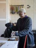Portrait of woman pouring dog food into bowl in dining room
