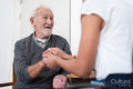 Female doctor holding senior patients hand in office