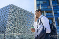 Businessman walking in business district and using phone