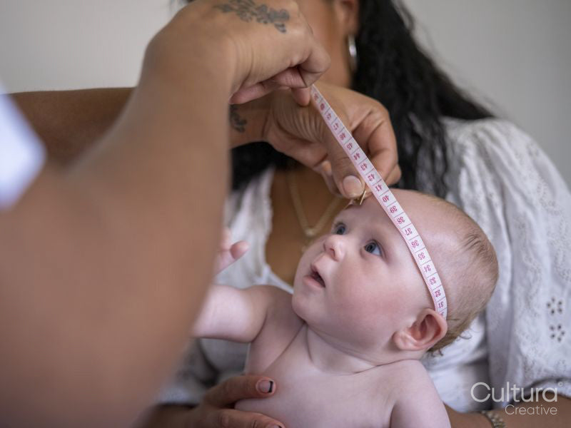 Nurse taking growth measurements of baby girl