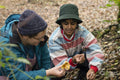 Female friends picking mushrooms in forest