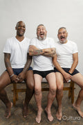 Portrait of smiling senior men in white t-shirts against gray background