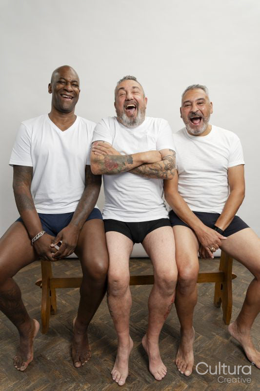 Portrait of smiling senior men in white t-shirts against gray background