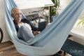 Smiling mature man lying in hammock and using digital tablet