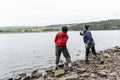 Mother and son skipping stones in lake