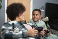 Mother and son playing video games at home