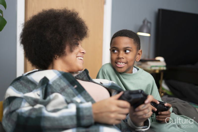 Mother and son playing video games at home