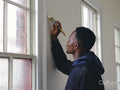 Man painting house walls white