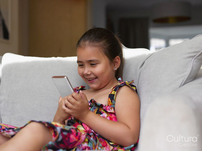 Girl looking at smart phone on sofa