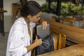 Woman sitting in hotel lounge, removing laptop from bag