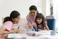 Mother with daughters playing with beads in living room