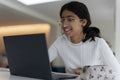 Schoolgirl doing homework using laptop