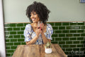 Smiling woman with glass of red wine at cafe table