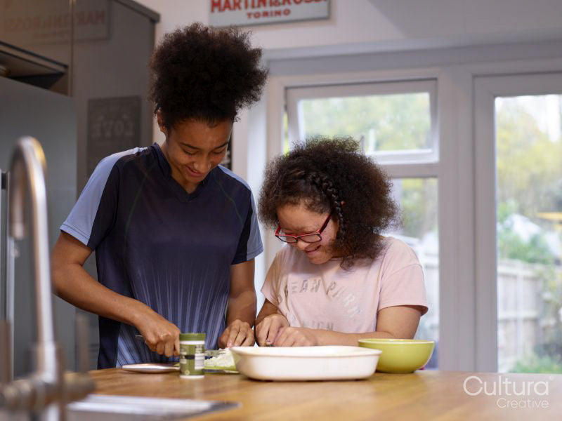 Sisters preparing food in kitchen
