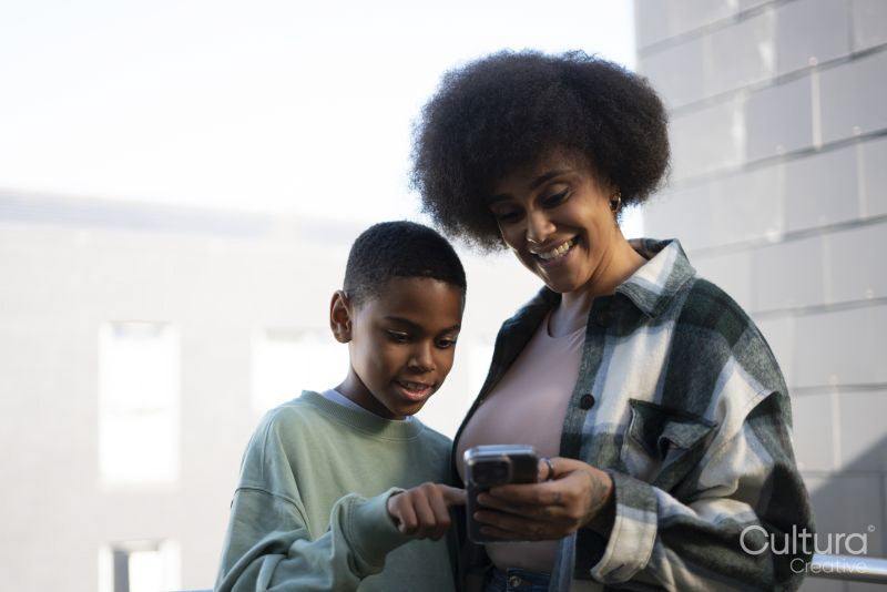 Smiling mother and son using smart phone