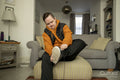Man sitting in living room getting dressed