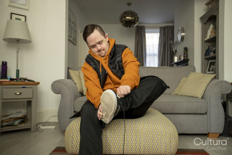 Man sitting in living room getting dressed