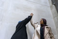 Two women wearing hijabs doing high-five