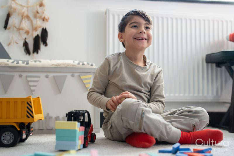 Boy sitting on floor and playing with toys