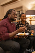 Mid adult couple eating meal in living room