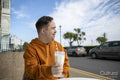 Man drinking milkshake in sidewalk cafe