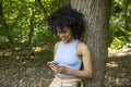 Young woman using smart phone in forest