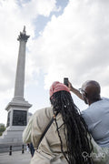 Happy mature couple photographing Nelson's Column while visiting city