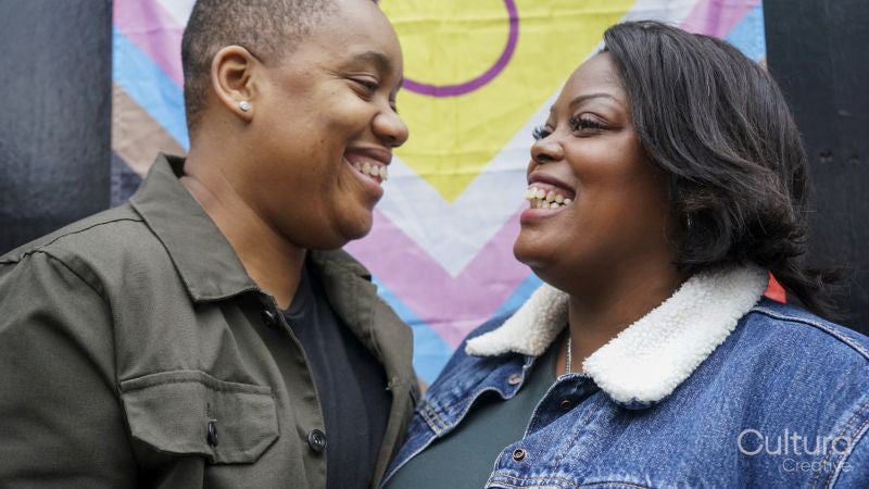 Two women in front of pride flag